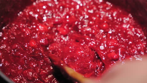 Cooking-And-Stirring-Cranberry-Sauce-With-Wooden-Spoon