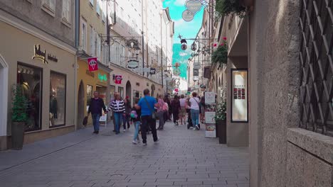 Tourists-and-shoppers-walking-along-Getreidegasse-in-Salzburg,-Austria