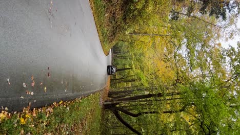 Car-driving-through-frame-walking-down-an-old-country-road-in-Frankfort,-Kentucky-during-fall---VERTICAL