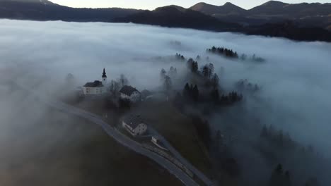 Imágenes-De-Drones-De-Un-Pueblo-Alpino-En-La-Niebla-De-La-Mañana