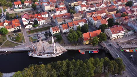AERIAL-Slow-Side-Panning-Shot-of-Klaipeda-Old-Town,-Ship-and-the-River,-Lithuania