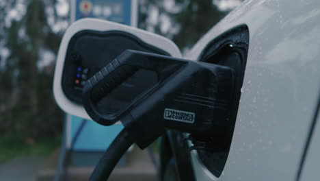 Plug-In-Connector-Into-Socket-of-Electric-Vehicle-at-Charging-Station,-Close-Up