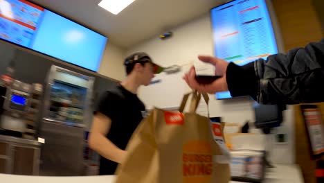 POV-delivery-food-courier-picking-up-paper-food-bag-in-Burger-King-restaurant-service-area---Brussels,-Belgium