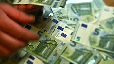 White-hands-methodically-organizing-5-Euro-bills,-Close-up-shot