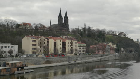 Prague-tracking-shot-of-a-tramway-along-the-Vltava-embankment-in-front-of-Vyšehrad-cathedral-on-a-cloudy-day