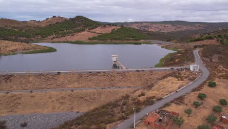 Aerial-towards-water-reservoir-in-Rural-landscape,-Alentejo