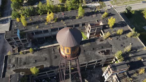 Old-rusty-water-tower-of-Packard-Plant-in-Detroit,-aerial-drone-view
