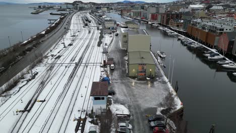 Flying-over-railway-tracks-close-to-Nidelven-river-in-Trondheim,-Norway
