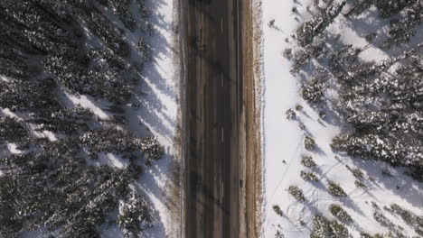 Aerial-top-down-shot-of-cars-driving-down-a-road-in-the-Colorado-Rockies