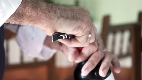 Slowmotion-shot-of-a-waiter-using-a-corkscrew-to-open-up-a-fresh-bottle-of-wine