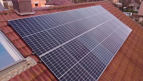 Drone-flying-over-set-of-solar-panels-installed-on-the-roof-of-house-with-orange-tiles