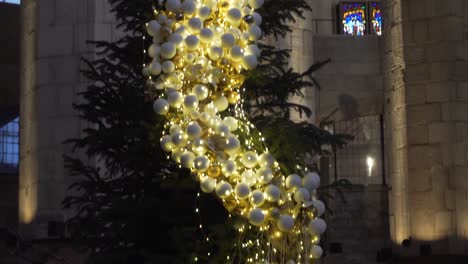 Christmas-Tree-covered-with-Yellow-Lights-and-White-Balls-in-Basilica-de-Santa-Maria-del-Mar,-Barcelona