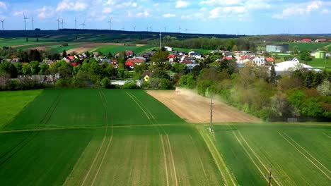 Traktor-Pflügt-Staubiges-Feld-In-Der-Nähe-Der-Häuser-In-Der-Ländlichen-Stadt