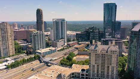 Slow-moving-aerial-shot-over-Buckhead-Atlanta-with-cars-driving-the-highway-near-the-subway