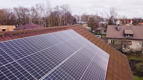 Solar-panels-mounted-on-tiled-roof-for-renewable-energy-source,-aerial-closeup