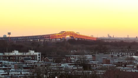 Beautiful-long-aerial-zoom-from-Philadelphia-south-neighborhood-of-Walt-Whitman-Bridge-with-golden-light