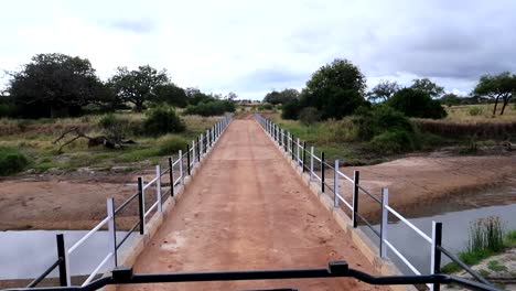 Crossing-a-bridge-on-the-savanna,-over-a-river-in-Africa