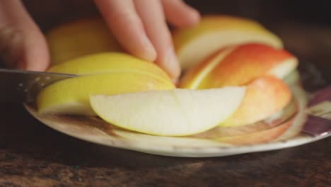 Manos-Cortando-Manzana-Fresca-En-Un-Plato-Usando-Un-Cuchillo-De-Cocina