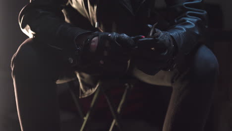 Person-checking-pliers-with-black-leather-gloves-and-then-puts-it-away