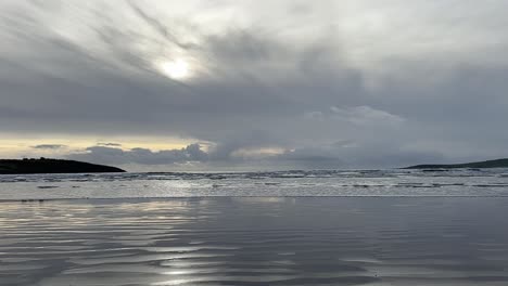 Wide-panoramic-slow-motion-sandy-beach-in-wintertime-with-sun-inside-clouds