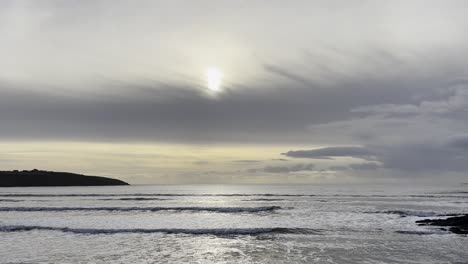 Frühe-Wintersonne,-Die-Von-Leichten-Wolken-Und-Silbernem-Licht-über-Wellen-Verdeckt-Wird,-Die-Zur-Irischen-Küste-Kommen