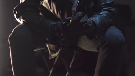 Criminal-checking-wrench-with-black-leather-gloves-and-puts-it-away