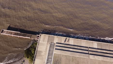Menschen,-Die-Entlang-Des-Flusses-Auf-Betonpflasterrand-Mit-Geometrischen-Formen-Spazieren,-Buenos-Aires-In-Argentinien