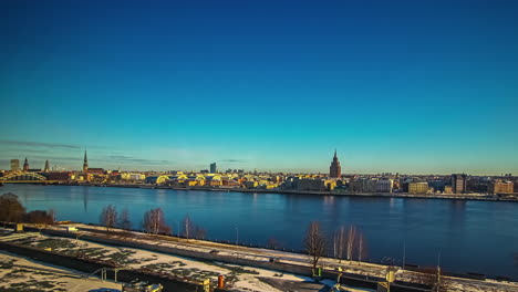 Riga-city-and-Daugava-river-during-golden-sunrise,-fusion-24-hours-time-lapse
