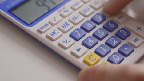 Hand-Uses-Calculator-In-Calculating-Numbers.-closeup