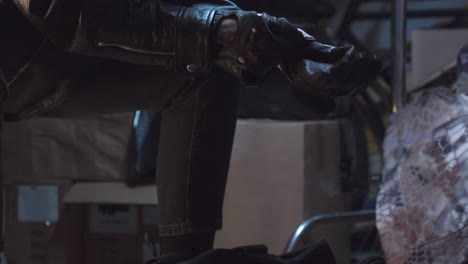 Robber-in-leather-jacket-pulling-on-gloves-stretching-his-hands