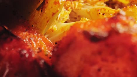 An-extreme-close-up-of-roasted-vegetables-including-cauliflower,-red-peppers,-and-green-peppers