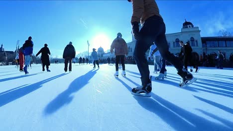 Low-Angle-POV-shot---Shadows-of-skaters-in-slow-motion-on-the-ice-rink-of-Budapest-City-Park,-Hungary---January-2023