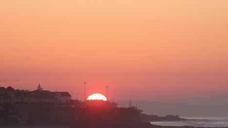 Timelapse-of-a-Beautiful-tropical-sunrise-over-the-sea-and-city-at-Estoril,-Cascais-near-Lisbon,-Portugal