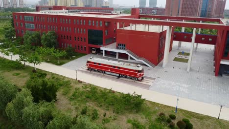 Cinematic-aerial-view-towards-antique-locomotive-at-Beijing-Jiaotong-University-Weihai-campus,-China