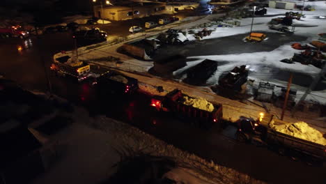 Nigh-aerial-as-trucks-do-snow-storm-cleanup-in-Buffalo,-New-York,-USA
