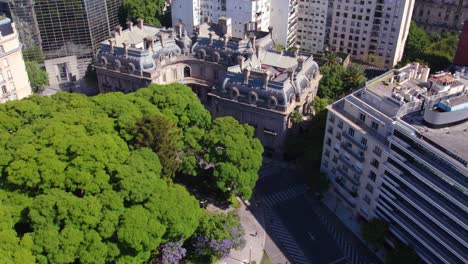 Aerial-view-of-the-San-Martin-Palace-in-the-Retiro-neighborhood-surrounded-by-trees-in-spring,-slow-motion