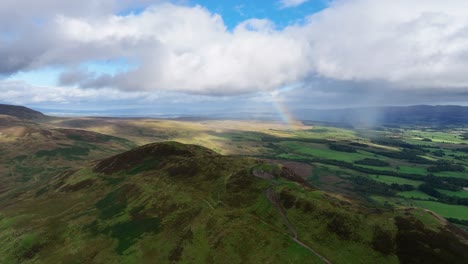 Drohnenannäherung-Des-Konischen-Hügels-In-Schottland-Mit-Regenbogen-Dahinter