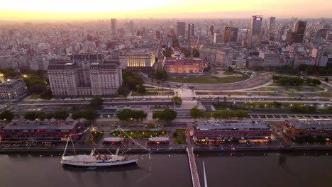 Aerial-orbit-establishing-an-epic-sunset-hour-shot-with-the-docks-of-Puerto-Madero-and-the-museum-ship-frigate-A