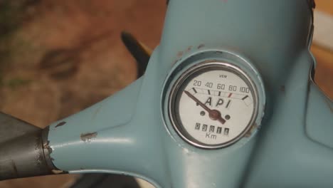 A-close-up-shot-panning-across-the-handlebars-of-a-blue-classic-vintage-Lambretta-API-scooter