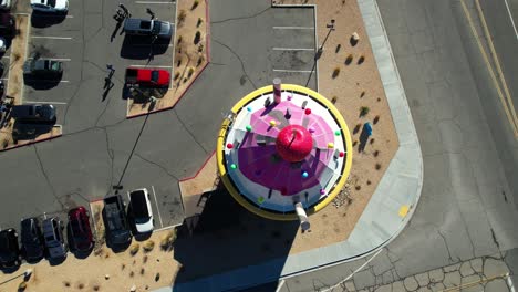 Topdown-descending-view-of-EddieWorld-gas-station-Colorful-Ice-cream-sign-and-water-tower