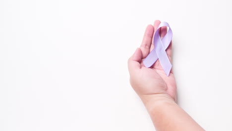 Detail-of-male-hand-holding-ribbon-in-light-purple-color-over-white-background