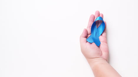Detail-of-male-hand-holding-ribbon-in-Light-blue-color-on-white-background