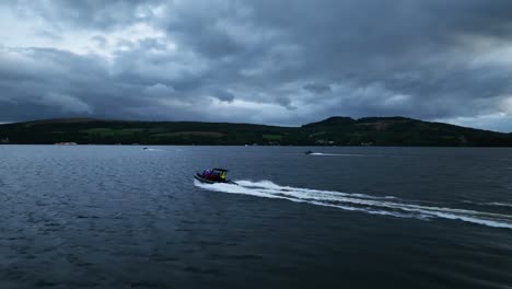 Cinematic-Drone-Shot-Tracking-Boat-Cruising-on-Loch-Lomond,-Scotland