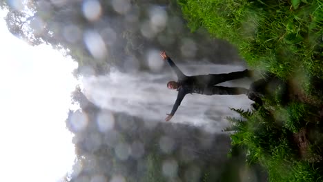 Man-shouting-and-raising-arms-at-the-base-of-Materuni-Waterfall