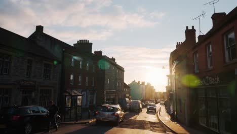 Establisher-handheld-shot-of-typical-Glastonbury-city-street,-golden-hour