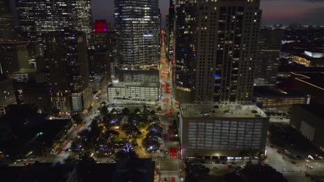 Drone-shot-flying-away-from-the-city-center-of-Houston,-evening-in-Texas,-USA