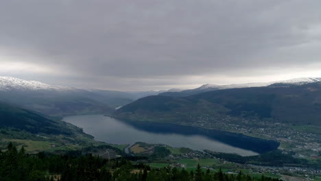 Rural-village-along-shores-of-Norwegian-fjord-on-cloudy-day,-Scandinavia