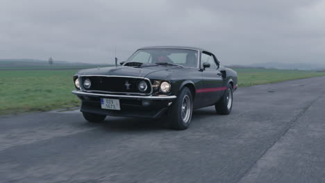 Ford-Mustang-Mach-1-Old-Timer-Moving-on-Wet-Road,-Classic-American-Sports-Car