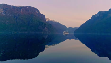 Aerial-view-of-Luxury-Cruiser-Ship-on-tranquil-Fjord-during-blue-hour-in-the-morning