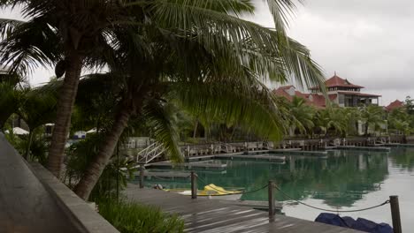 Seychelles-Eden-island,-Villas-with-coconut-palm-trees,-calm-sea-water
